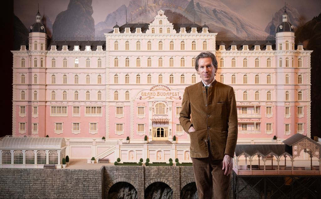 Image may contain Wes Anderson Architecture Building Housing House Adult Person Clothing Coat Bench and Furniture